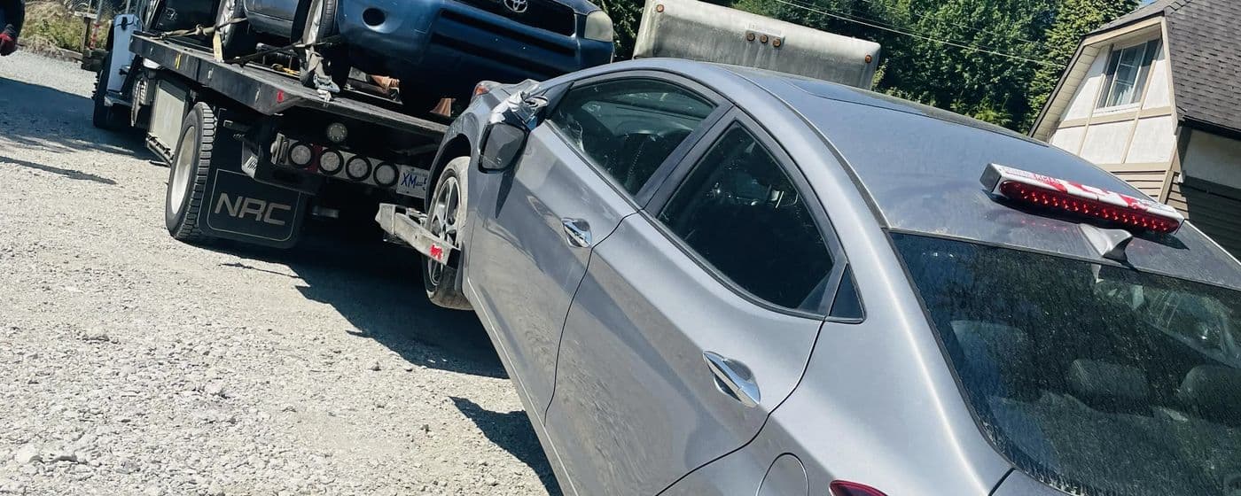 Full Time Towing flatbed truck picking up a junk car in Surrey